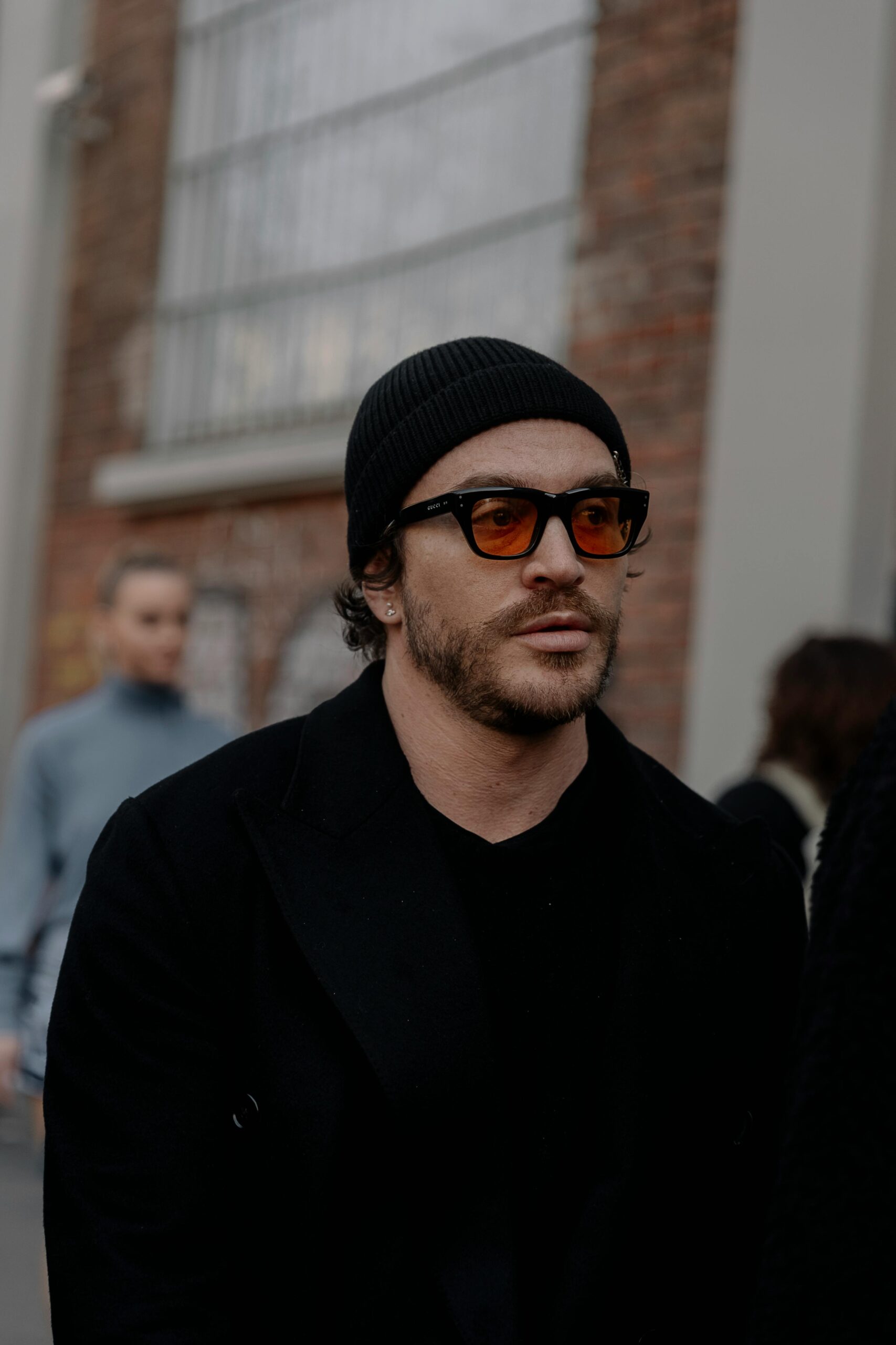 Stylish man with sunglasses at Milan street, showcasing urban fashion.